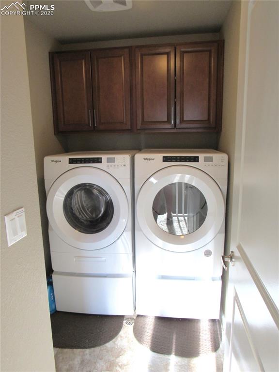 Image 20 of 25: Upper-level laundry with built-in cabinetry