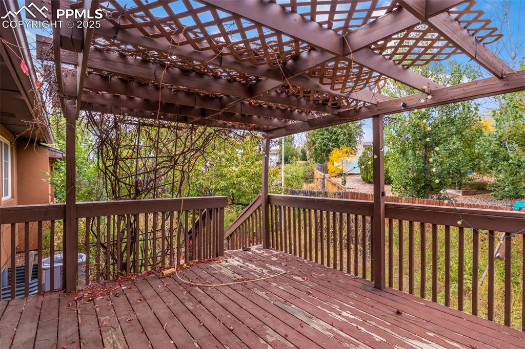 Image 29 of 34: A deck with a grape-vine trellis