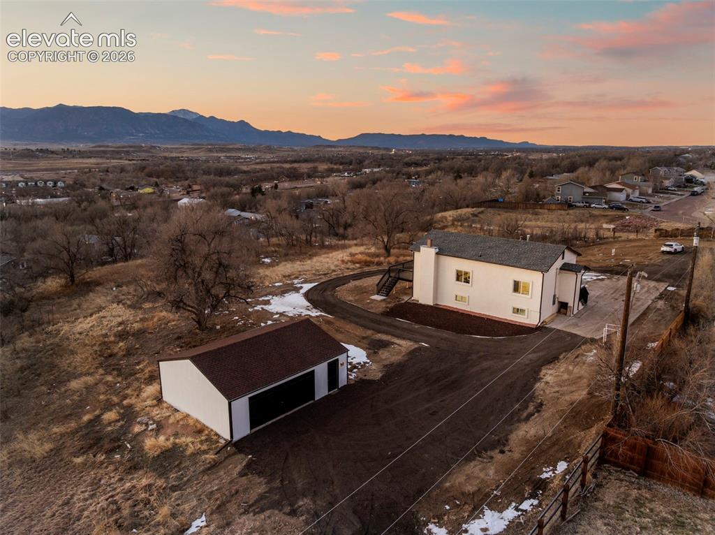 Image 1 of 50: Single-family residence featuring a detached garage, expansive driveway, an