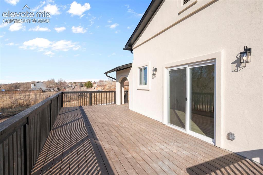 Image 11 of 50: Spacious outdoor deck featuring wood-finish flooring and a dark wood railin