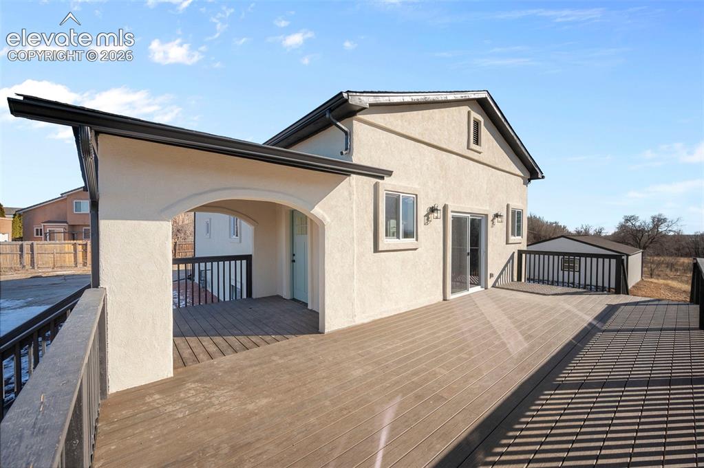 Image 12 of 50: Spacious composite deck with stucco exterior