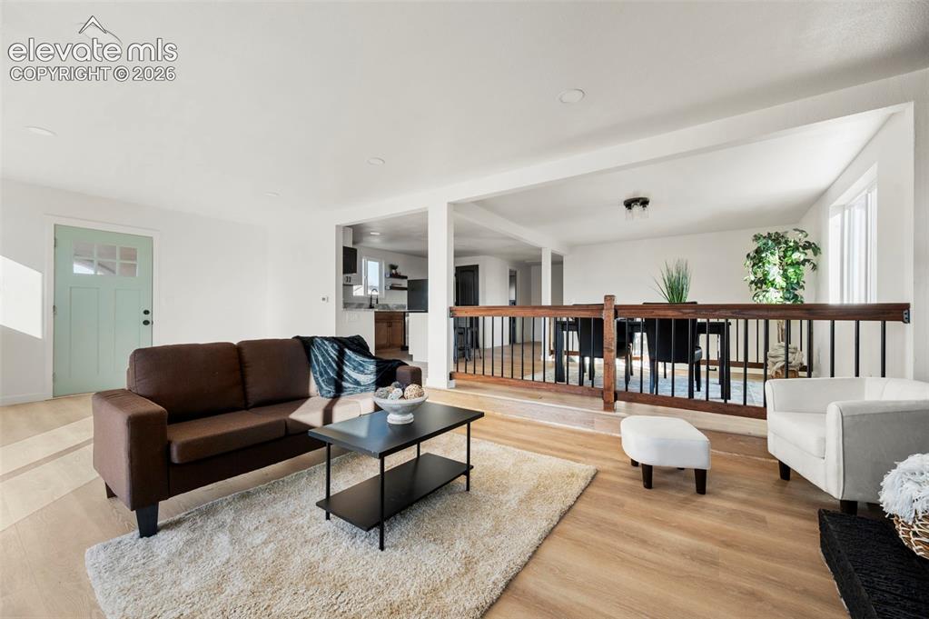 Image 18 of 50: Bright living area featuring light wood-finish flooring, recessed lighting,