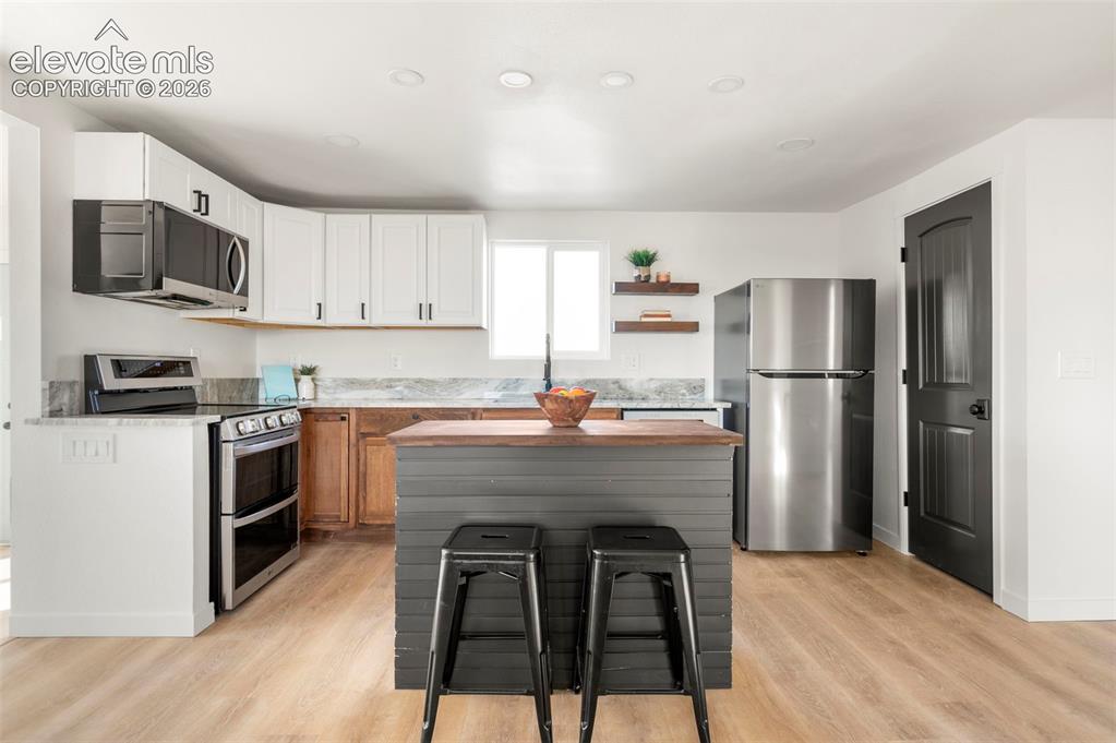 Image 22 of 50: Kitchen featuring a wood-finish floor and recessed lighting