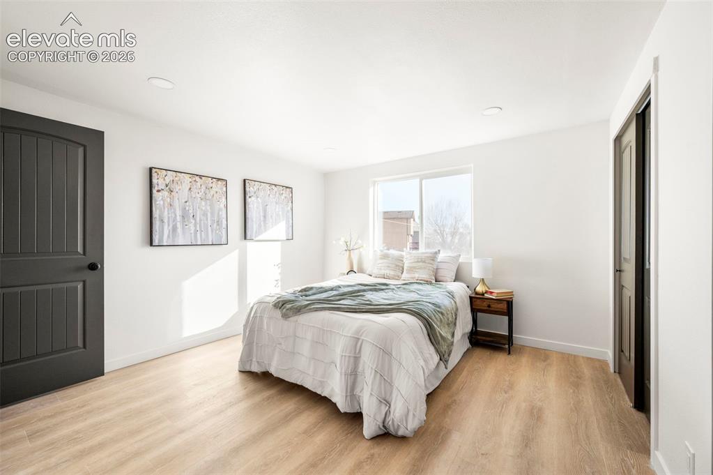 Image 26 of 50: Bright room featuring light wood-finish flooring, white walls, and recessed