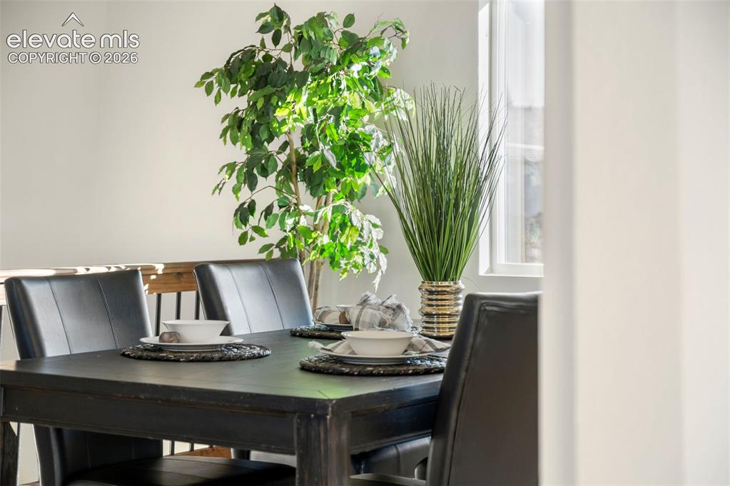 Image 43 of 50: Dining area featuring a dark-finish table with upholstered chairs, abundant