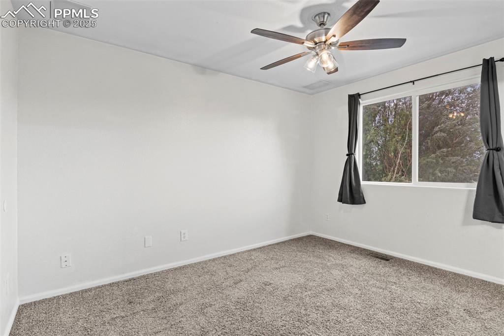 Image 21 of 39: Carpeted spare room with a ceiling fan and baseboards
