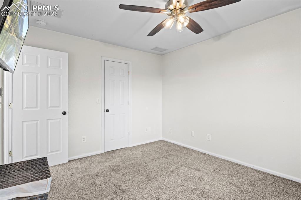 Image 24 of 39: Unfurnished bedroom with carpet flooring and ceiling fan