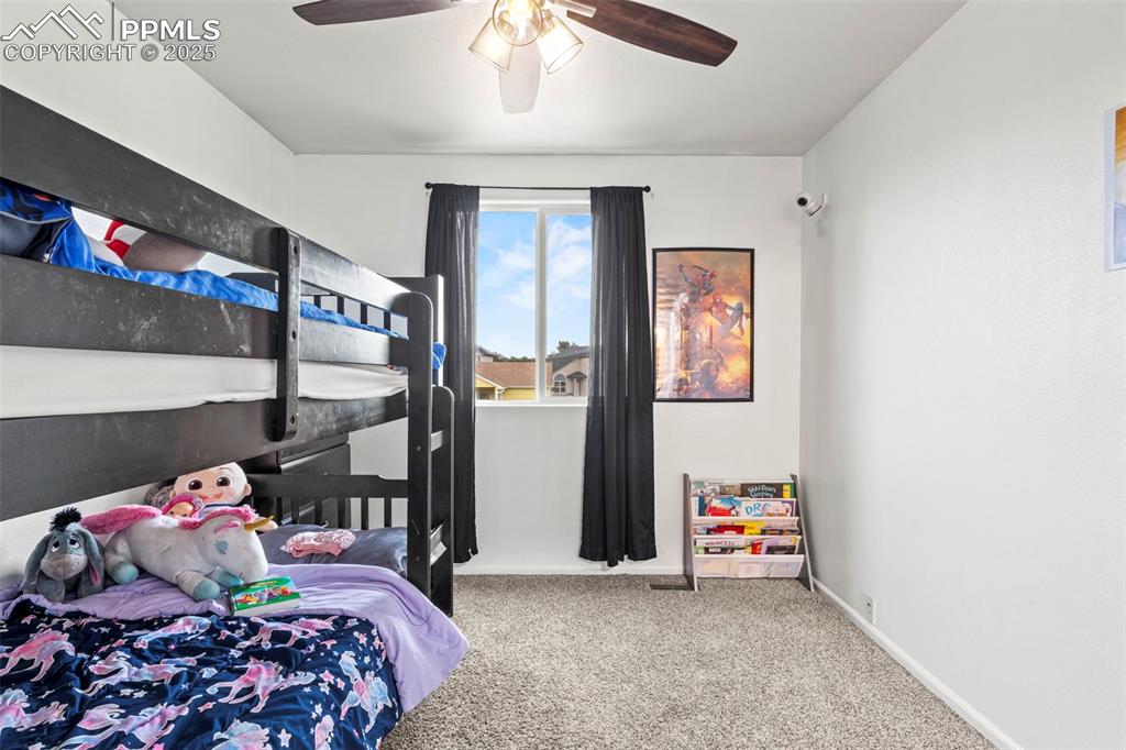 Image 29 of 39: Carpeted bedroom with baseboards and ceiling fan