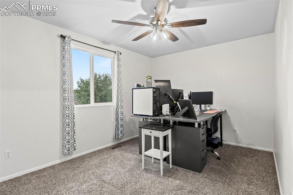 Image 33 of 39: Office with ceiling fan and carpet flooring