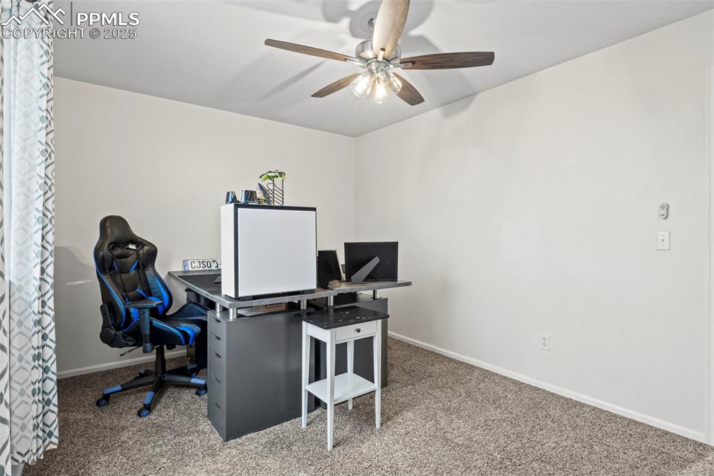 Image 34 of 39: Office area with carpet flooring and a ceiling fan