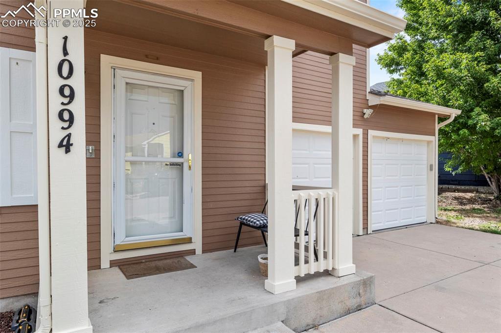 Image 5 of 39: Entrance to property featuring covered porch and a garage