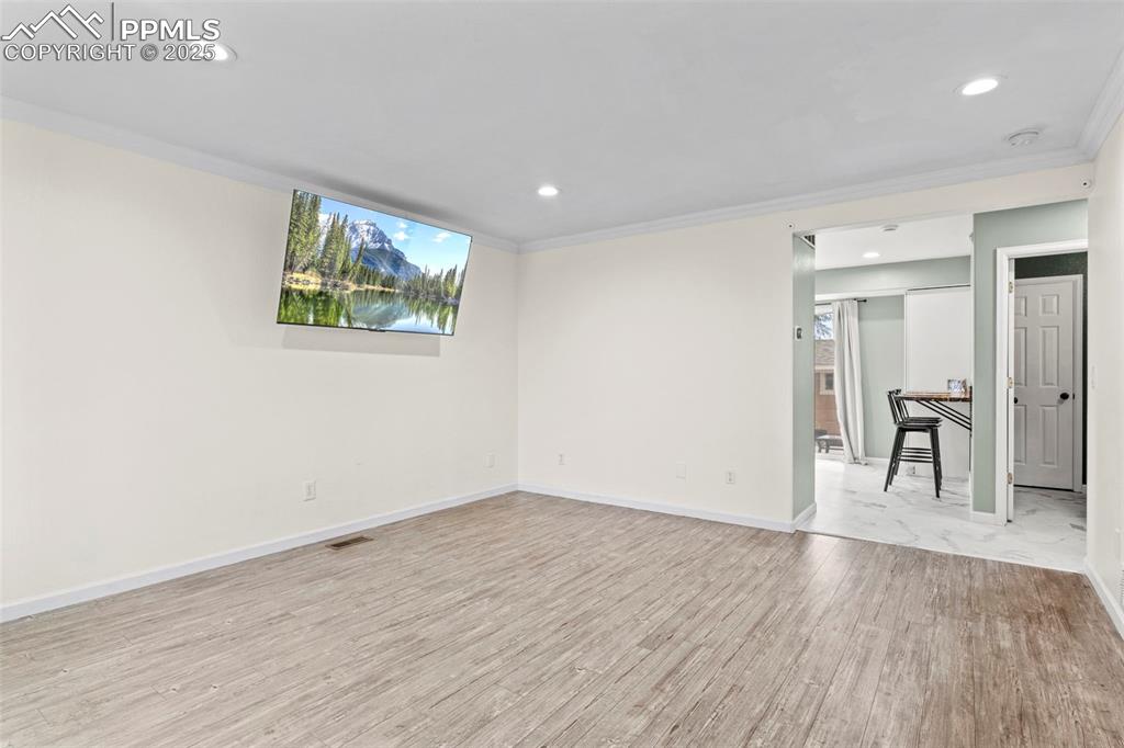 Image 7 of 39: Spare room with ornamental molding, light wood-style flooring, recessed lig