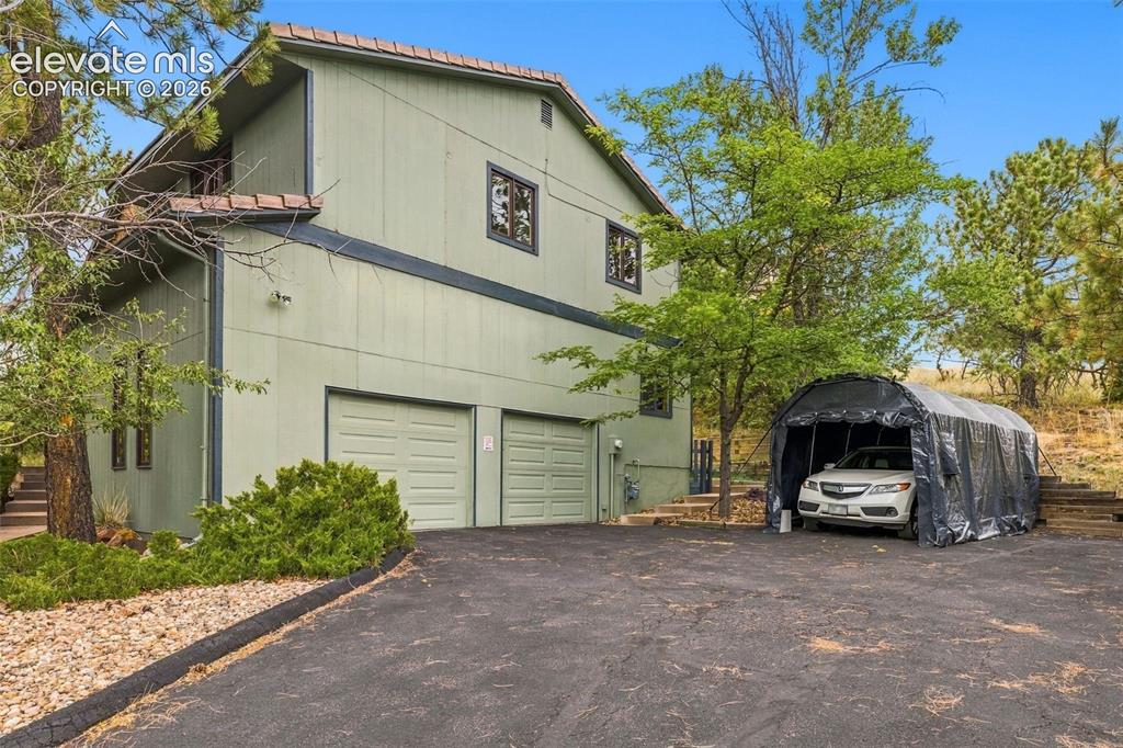 Image 2 of 49: Oversized two car garage and detached carport.