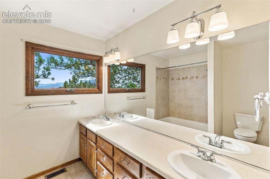 Image 28 of 49: Upper level, hall bath has an amazing view, double vanities and a huge line