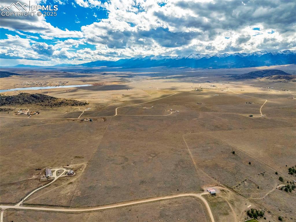 Image 11 of 14: Aerial view of sparsely populated area featuring mountains and a desert lan