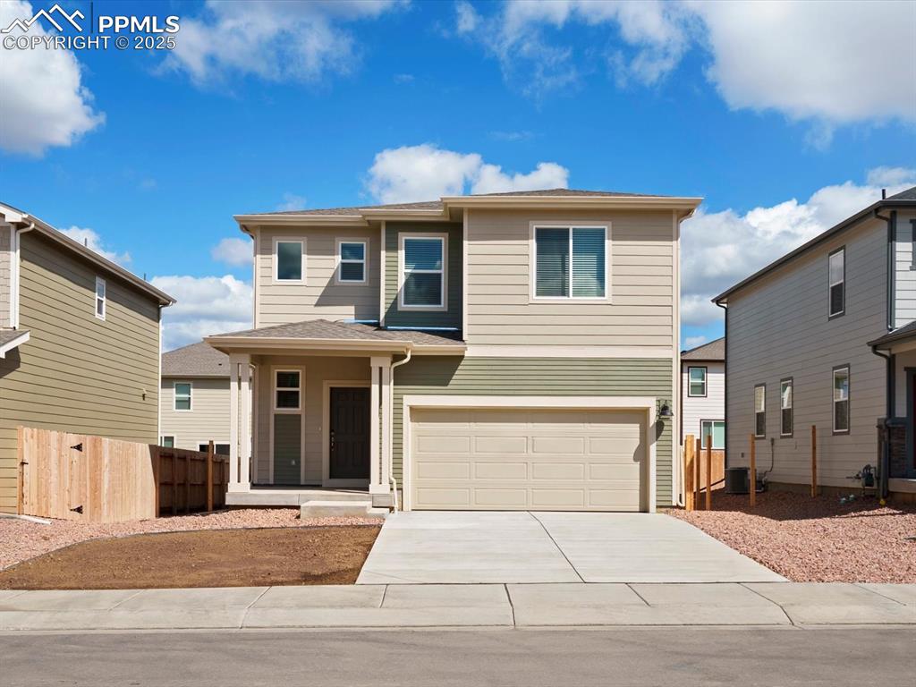 Caption: View of front facade featuring concrete driveway and an attached garage