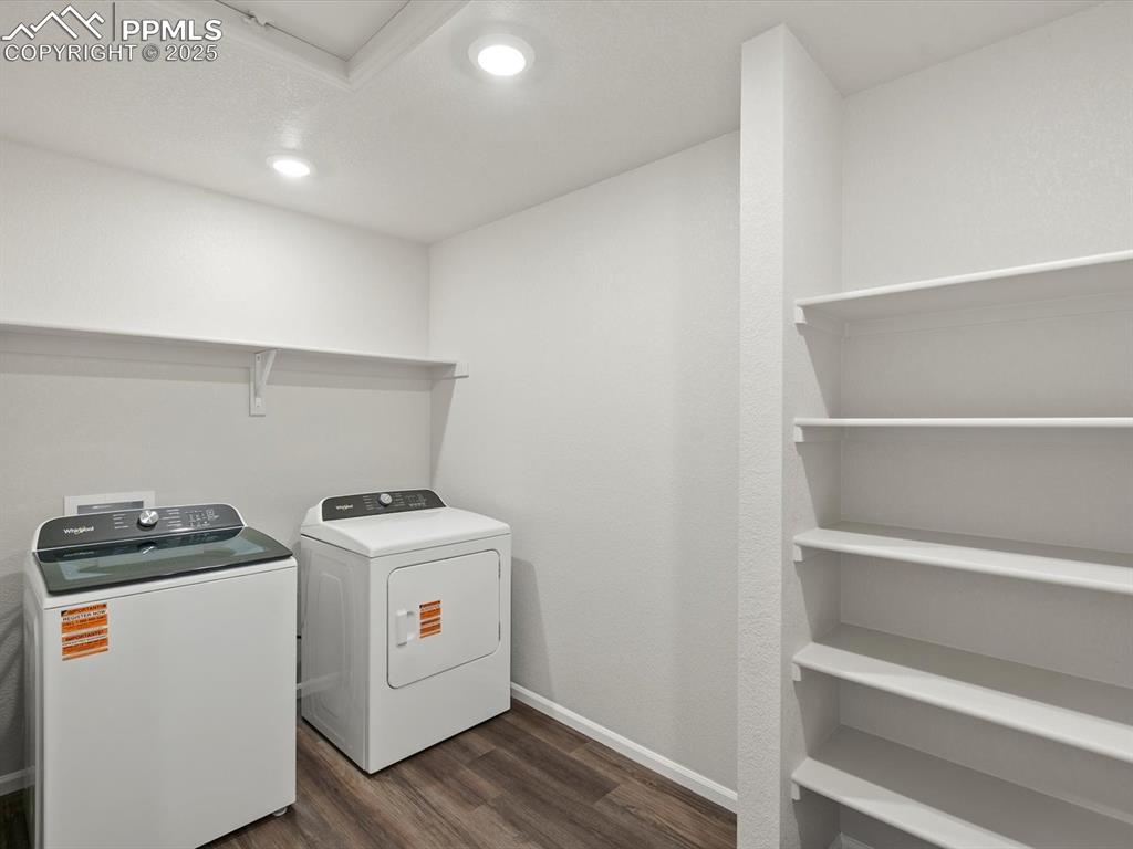 Image 11 of 25: Laundry room with dark wood-style flooring, washing machine and dryer, and