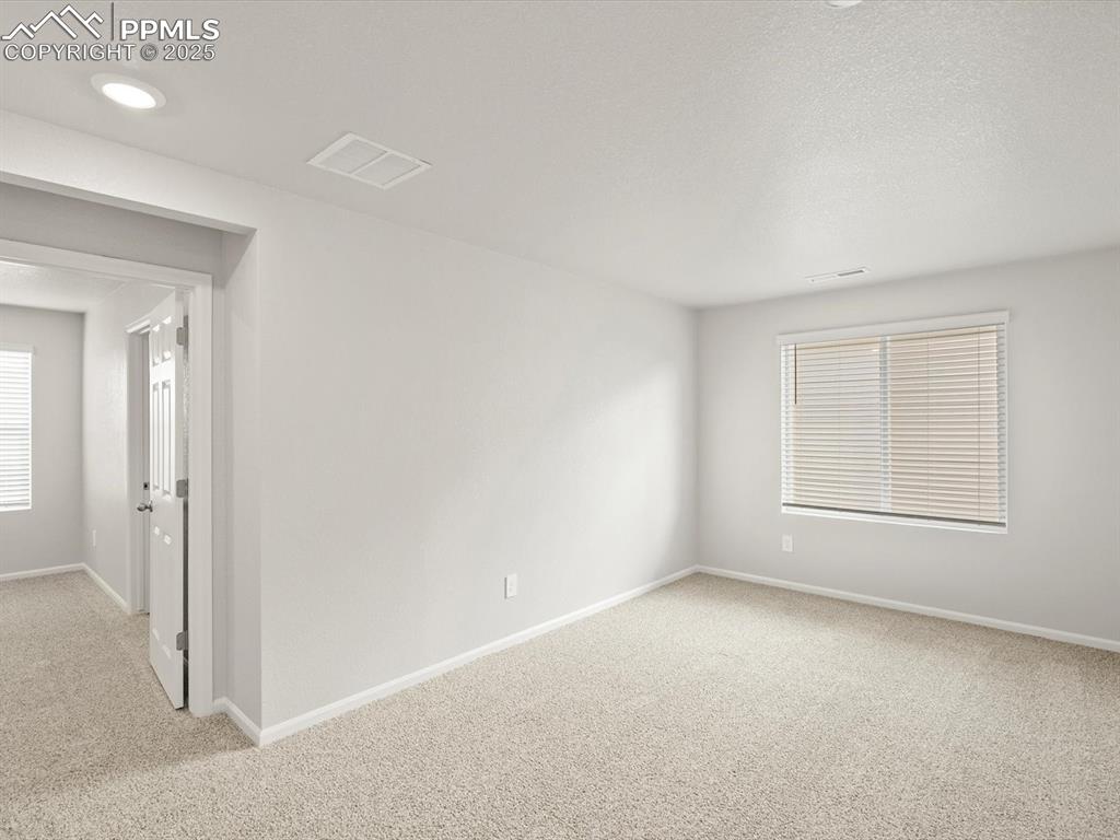 Image 12 of 25: Unfurnished room featuring light colored carpet and a textured ceiling