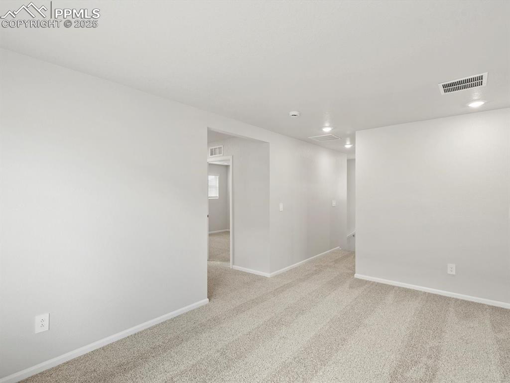 Image 13 of 25: Unfurnished room with light colored carpet and recessed lighting