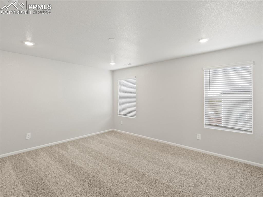 Image 14 of 25: Spare room with carpet, a textured ceiling, and recessed lighting