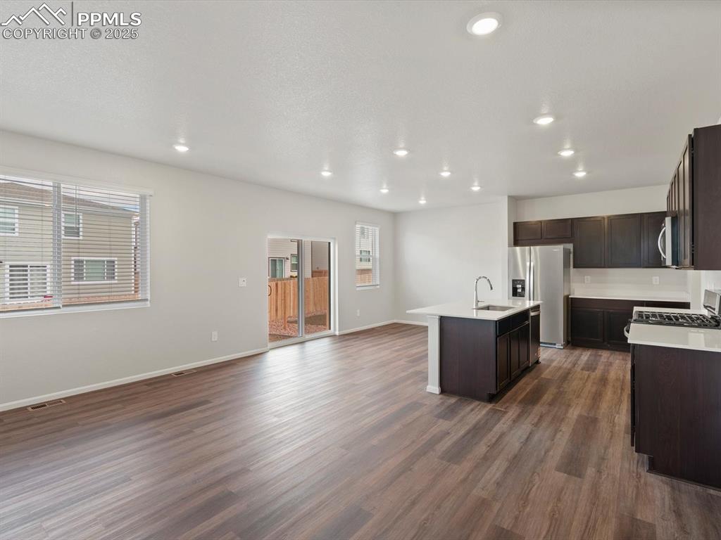 Image 2 of 25: Kitchen featuring open floor plan, recessed lighting, an island with sink,