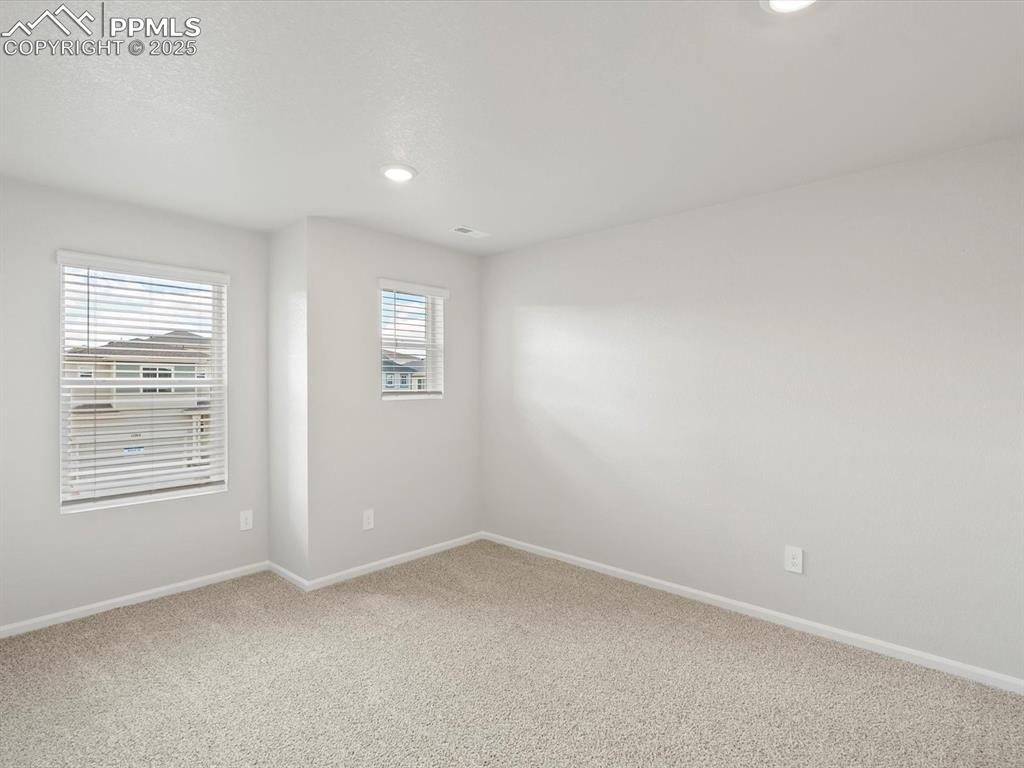 Image 21 of 25: Empty room with carpet flooring and recessed lighting