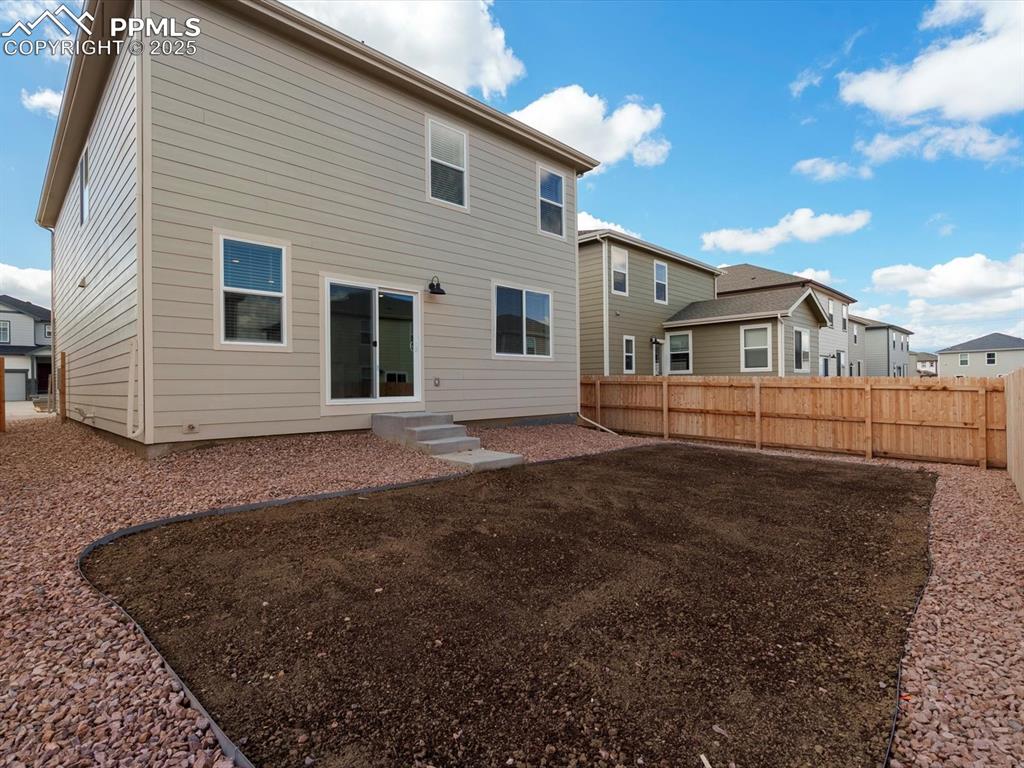 Image 23 of 25: Rear view of house featuring a residential view and a fenced backyard