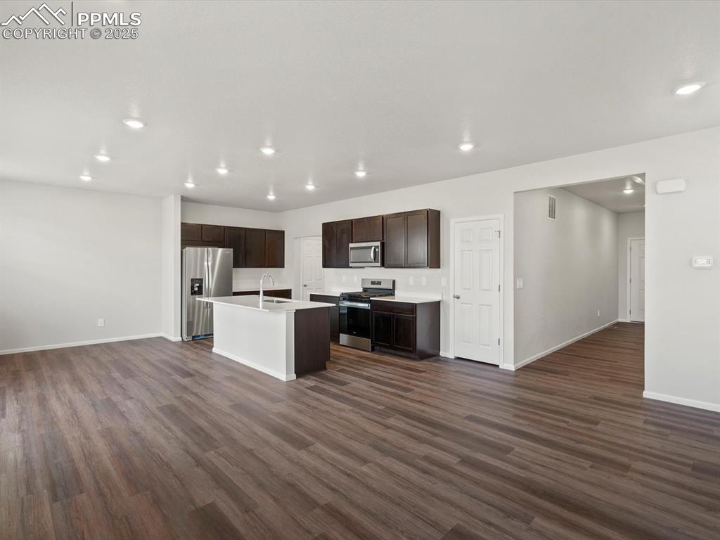Image 4 of 25: Kitchen featuring open floor plan, recessed lighting, appliances with stain