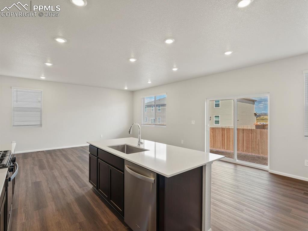 Image 7 of 25: Kitchen with stainless steel appliances, dark wood-style flooring, recessed