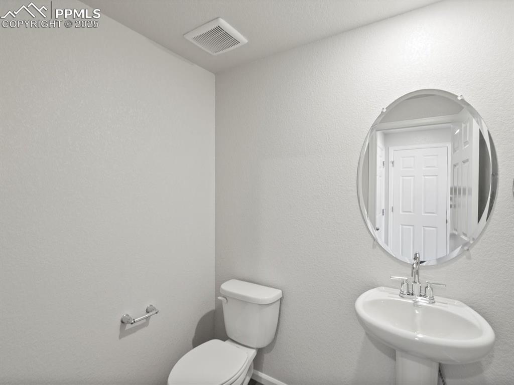 Image 8 of 25: Bathroom featuring a textured wall and toilet