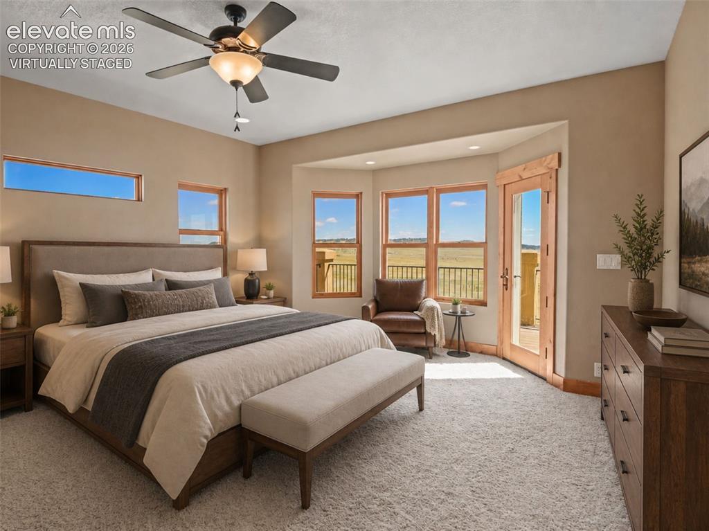 Image 17 of 50: primary bedroom with walkout to deck. virtually staged
