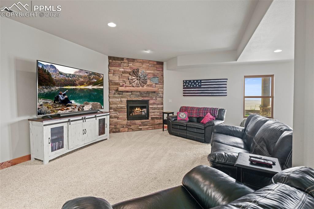 Image 32 of 50: lower great room with fireplace, bar, and walkout access