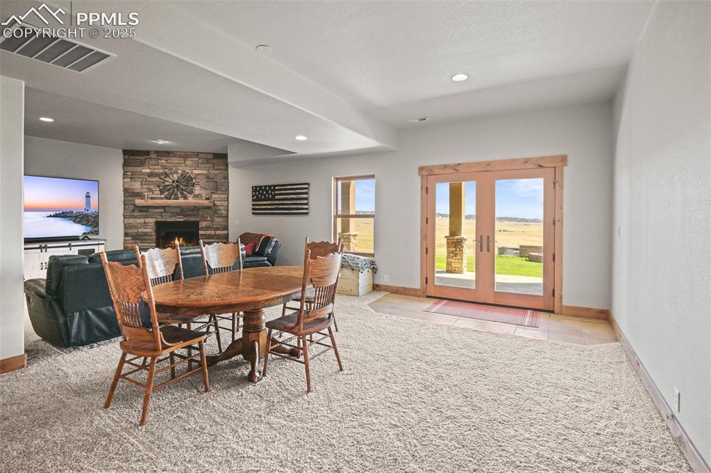 Image 33 of 50: lower great room with fireplace, bar, and walkout access