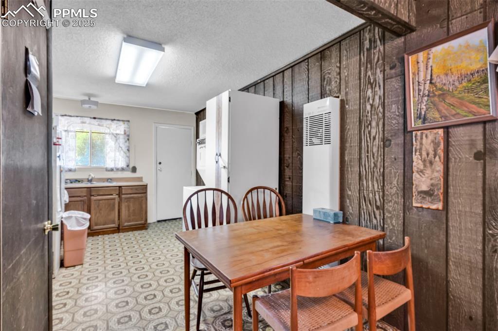 Image 10 of 33: Dining area with a heating unit, a textured ceiling, and light flooring