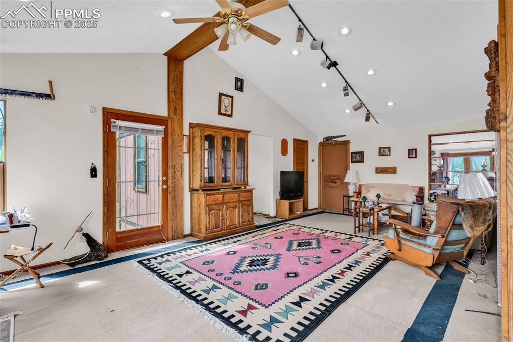 Image 22 of 33: Living area with high vaulted ceiling, a ceiling fan, recessed lighting, an