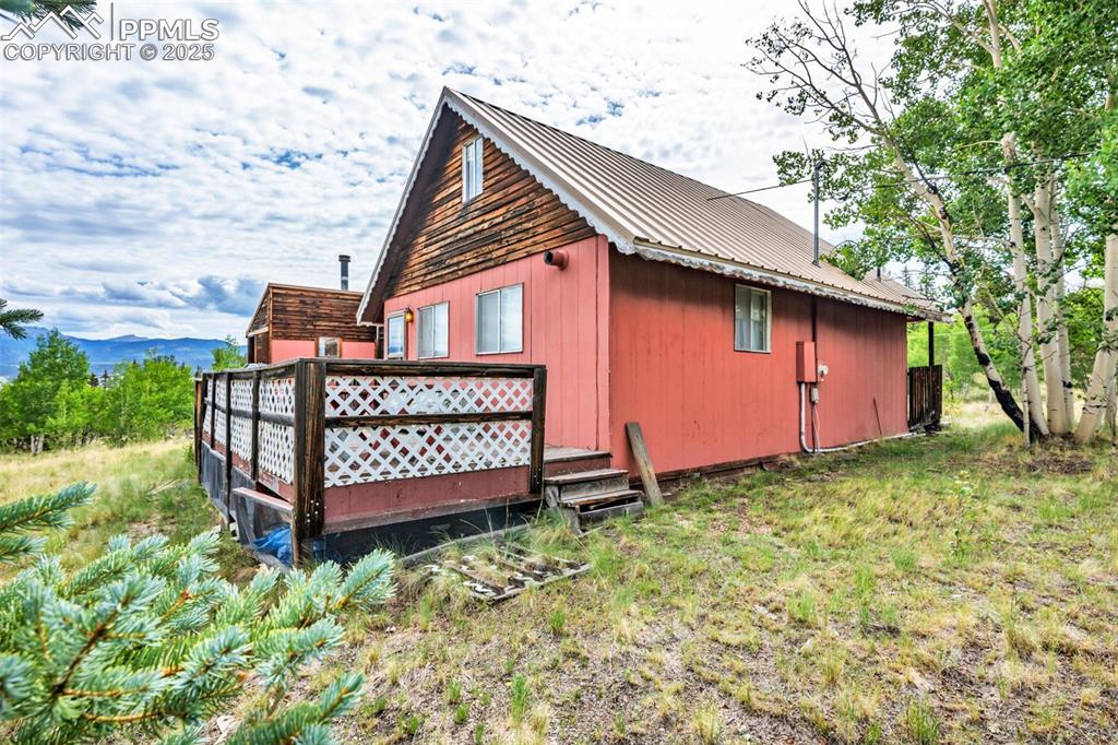 Image 26 of 33: View of side of home with a metal roof