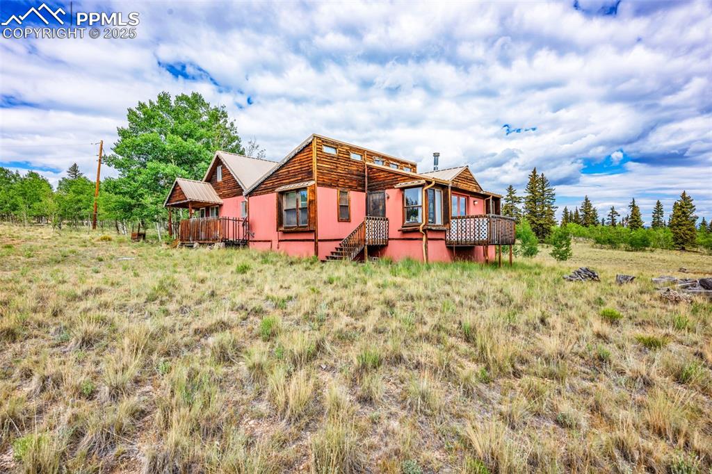 Image 5 of 33: Back of house with a wooden deck and stairs