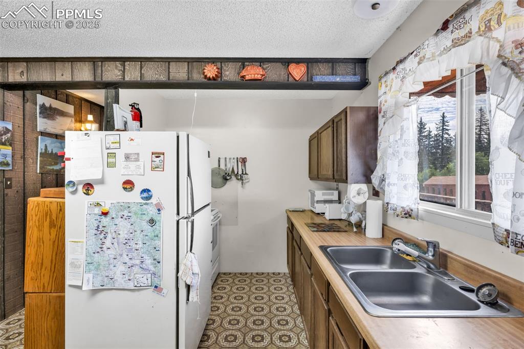 Image 6 of 33: Kitchen featuring white appliances, light countertops, and a textured ceili