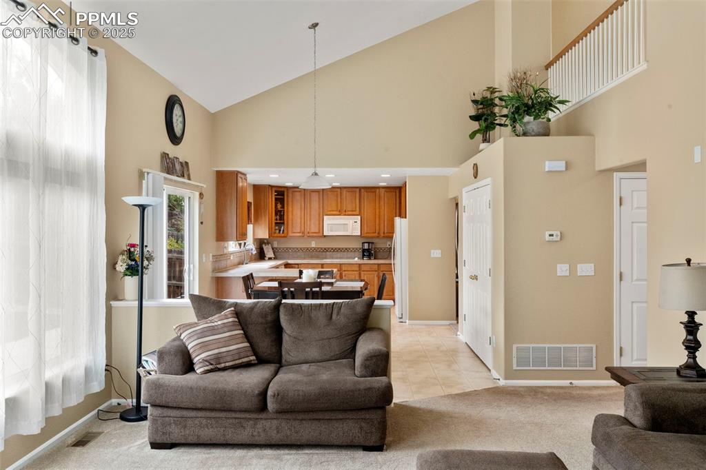 Image 17 of 38: View from vaulted family room into the kitchen area