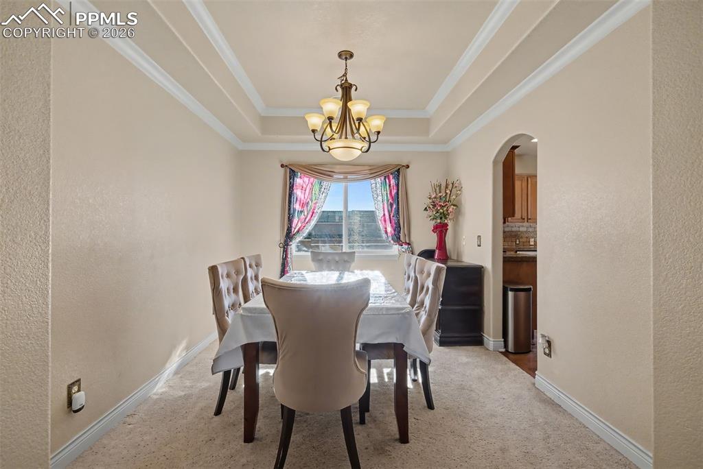 Image 12 of 49: Dining room with coffered ceiling, chandelier 