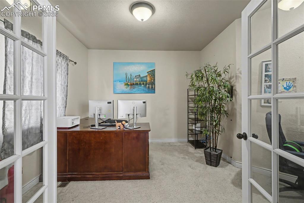 Image 26 of 49: Main level office with glass french doors 