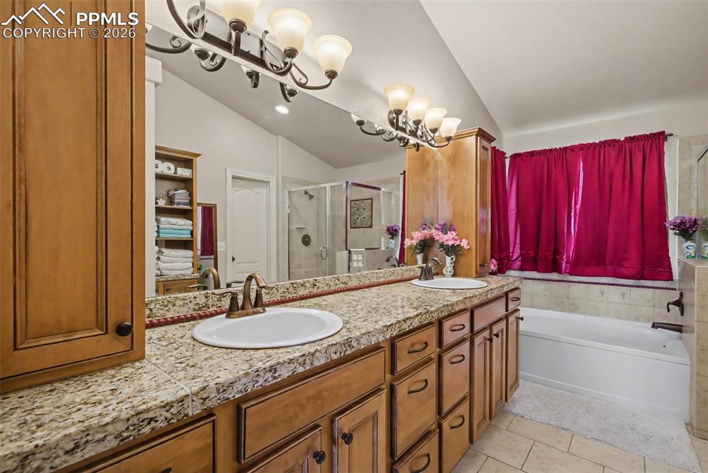 Image 30 of 49: Primary bath with granite countertop and double sinks