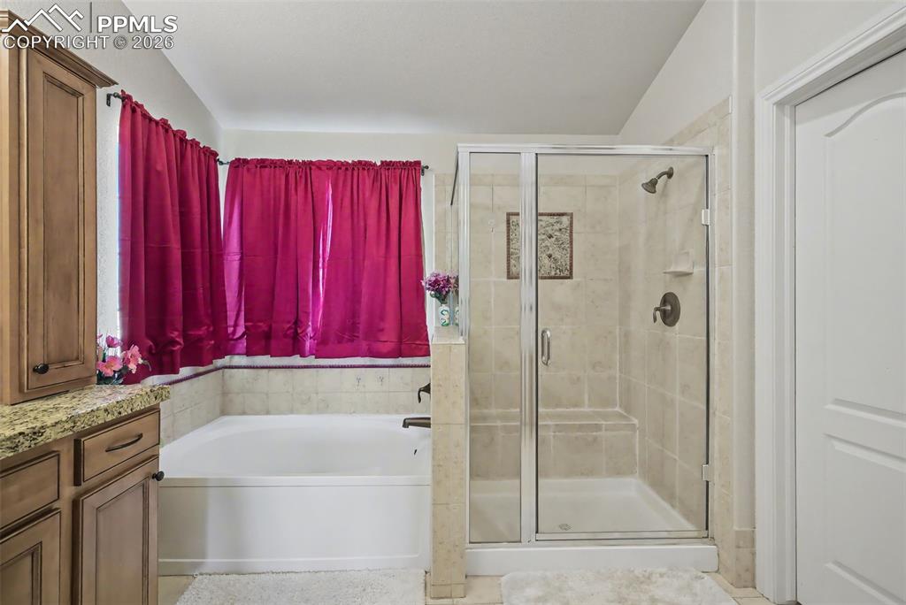 Image 31 of 49: Garden tub and walk-in shower with bench
