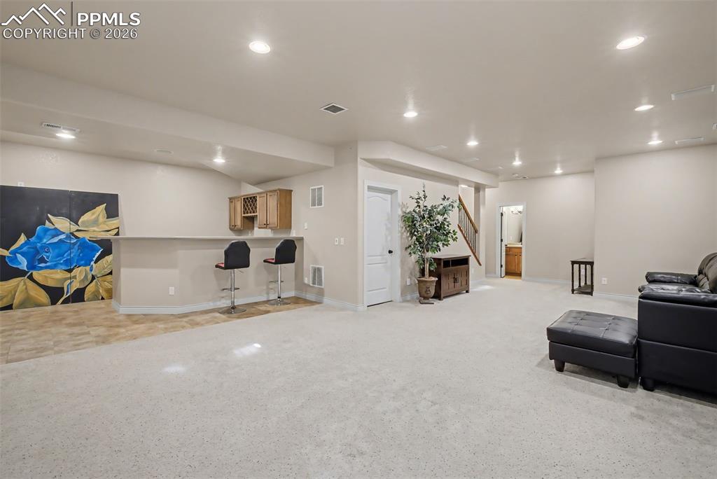 Image 35 of 49: Family Room/Rec Room area with wet bar in basement