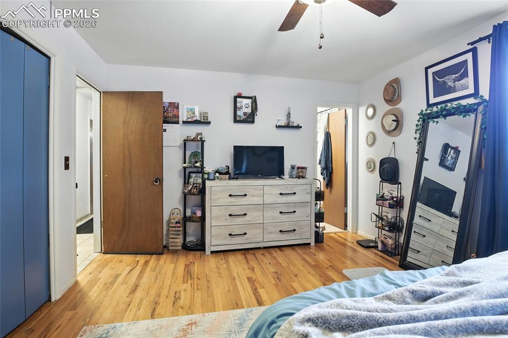 Image 18 of 35: Bedroom with light wood finished floors, a ceiling fan, and a closet