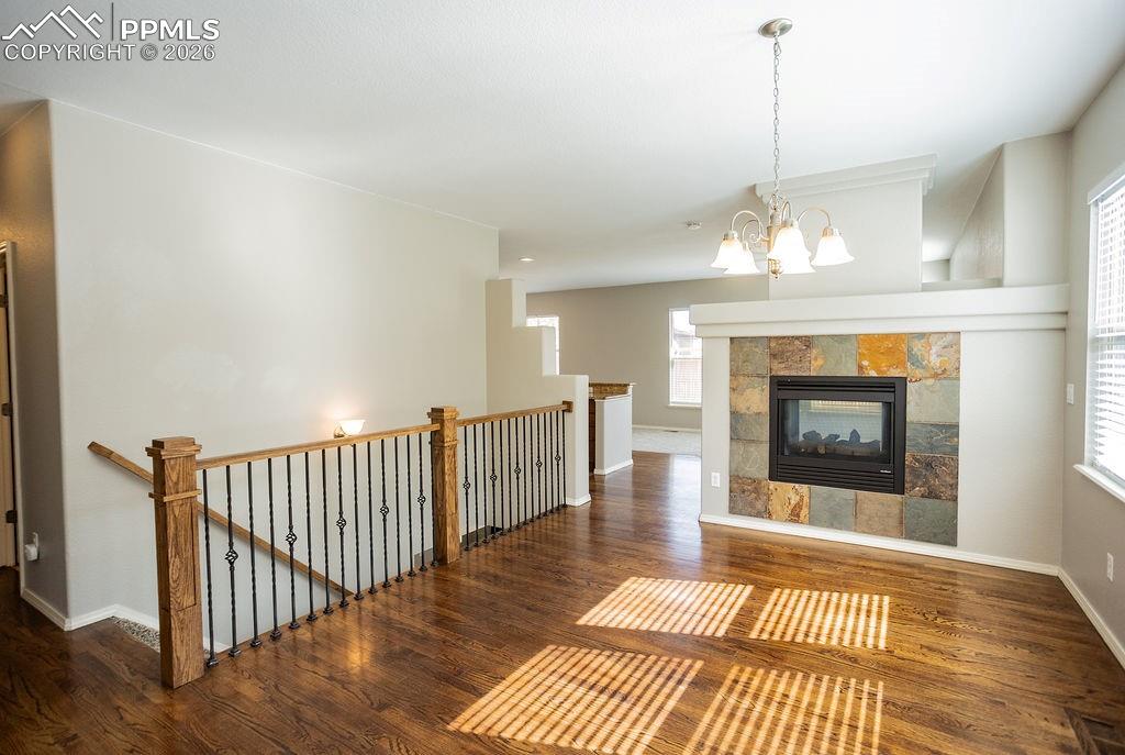 Image 3 of 49: Unfurnished living room featuring dark wood-type flooring, a tile fireplace