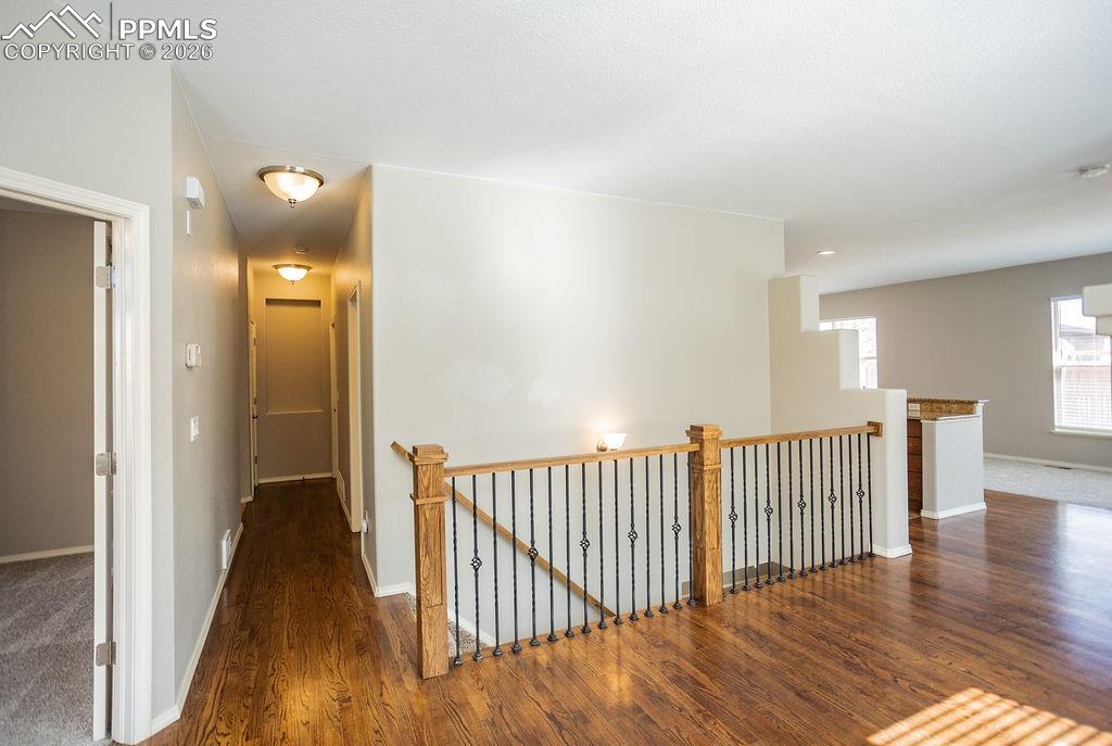 Image 4 of 49: Corridor featuring an upstairs landing and dark wood-style flooring