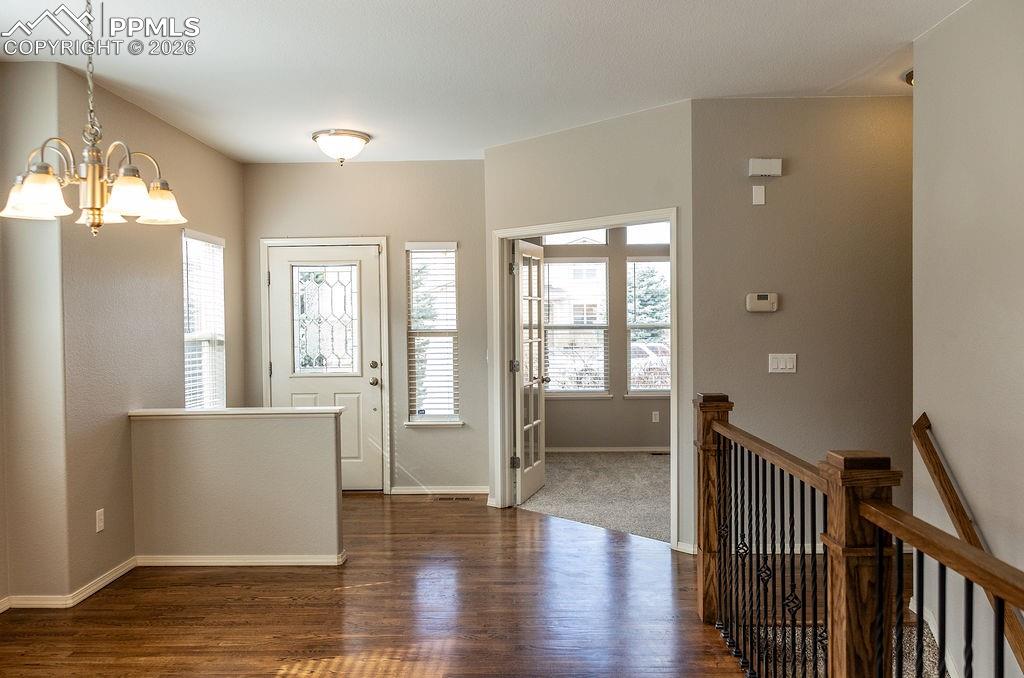 Image 5 of 49: Foyer entrance featuring dark wood-style floors and a chandelier