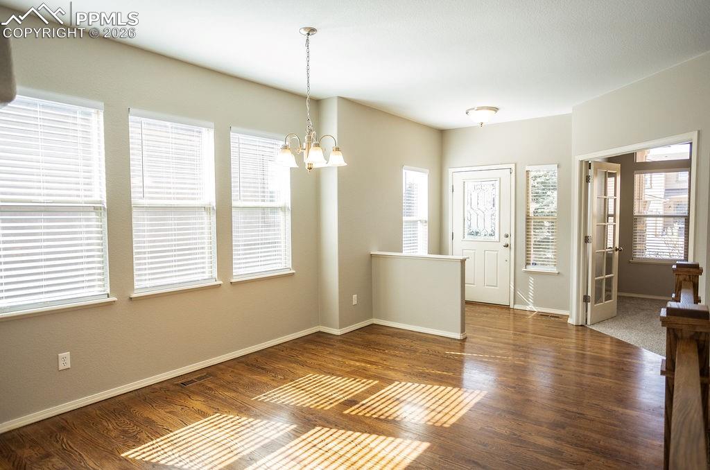 Image 6 of 49: Entrance foyer with a chandelier and dark wood-style floors