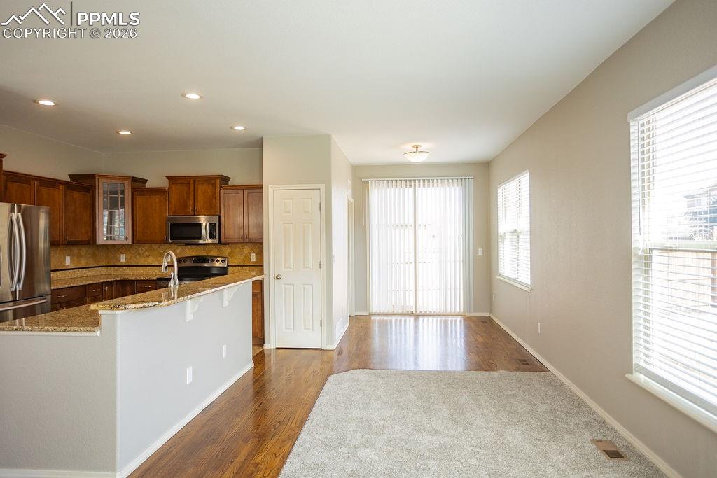 Image 9 of 49: Kitchen with glass fronted cabinets, stainless steel appliances, dark wood 